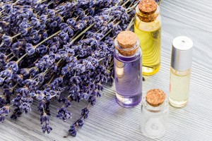 Lavender and cosmetic oil on wooden background.